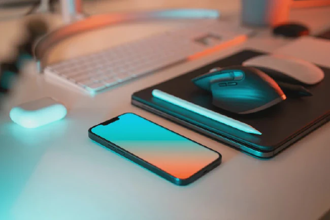 Apple iPhone and Mac on desk.